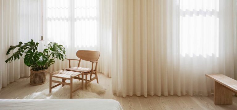 Drapes by The Hackney Draper define the primary bedroom, with a Viabizzuno pendant and Carl Hansen pendant.