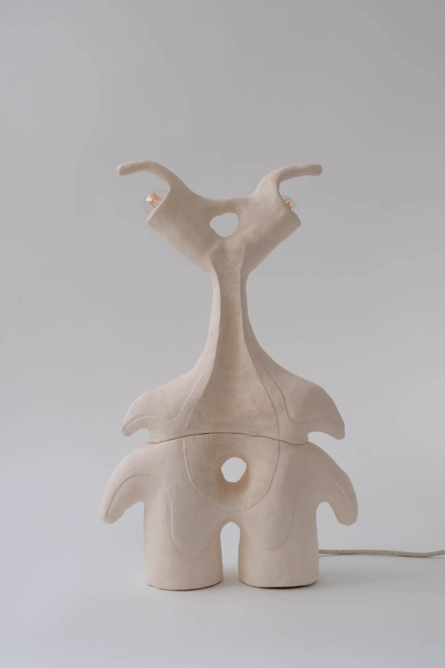 A cream sculptural lamp.