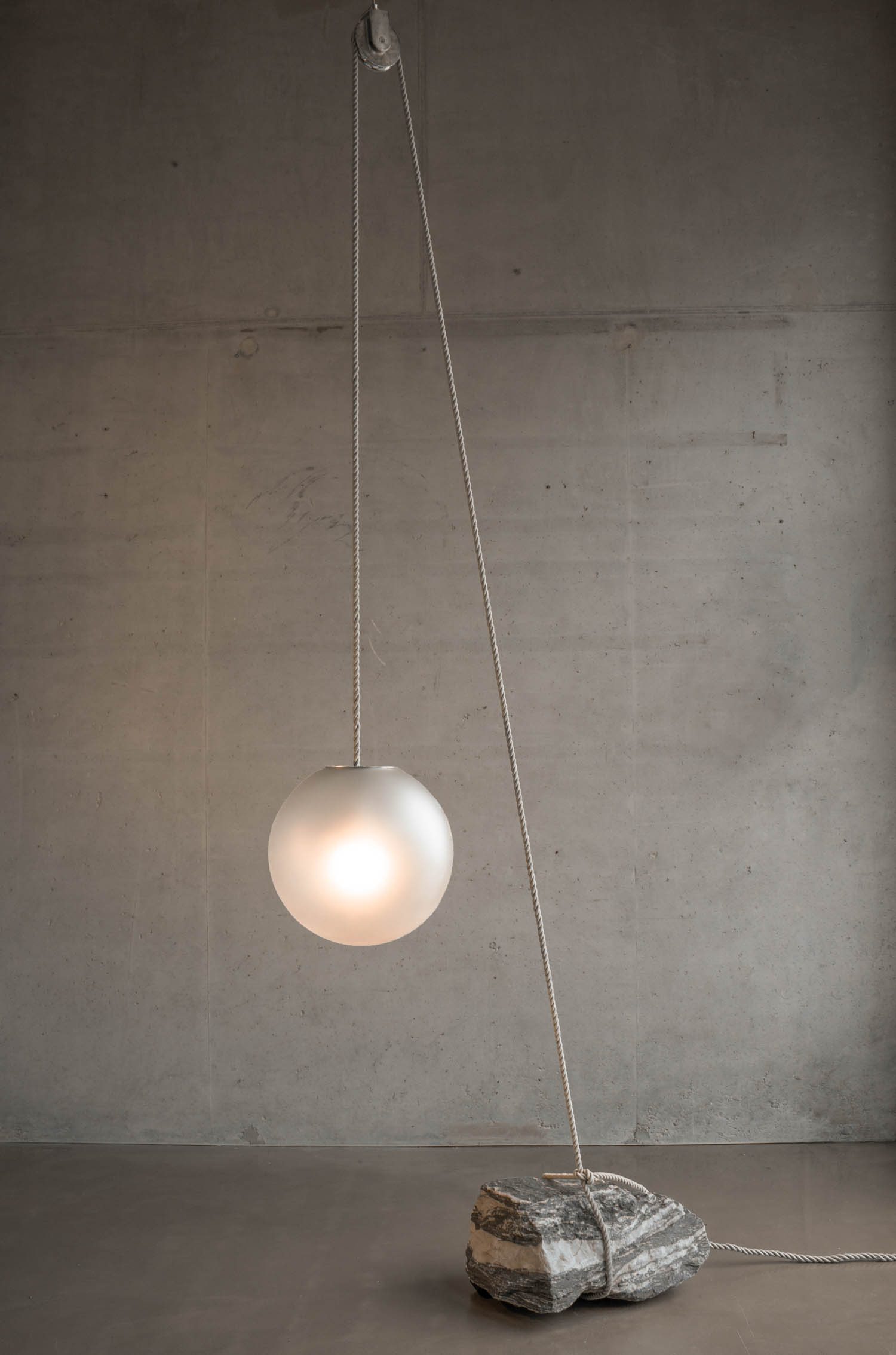 A pendant light hanging from a delicate chain