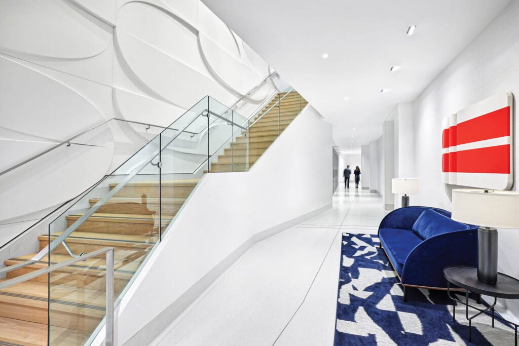 Opposite another Moreland, a custom CNC-cut pattern of fractured ovals forms the 3-D MDF wall of the grand hall stair.