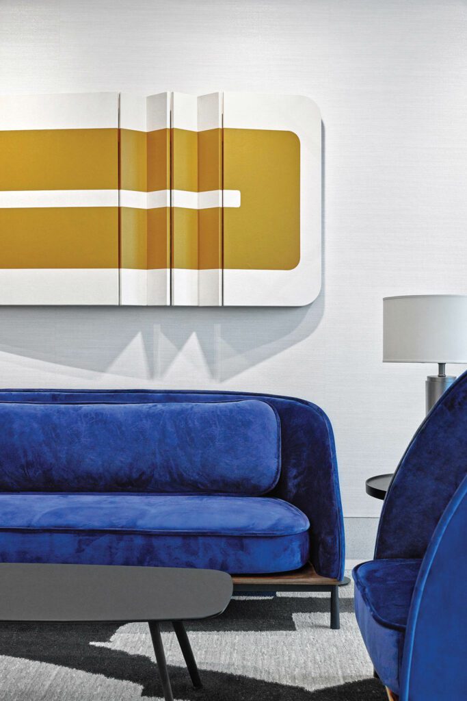 a gold and white sculpture above a blue sofa
