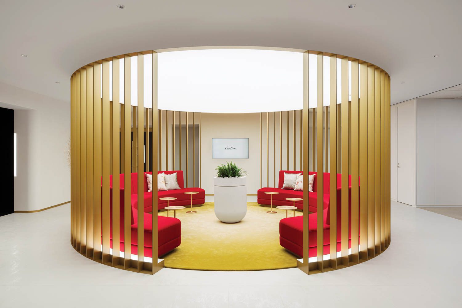 A Cartier office in Tokyo by design firm I IN features upholstery in the brand’s signature red paired with gold-finished furnishings and artwork, plus a raised tatami-mat employee lounge.