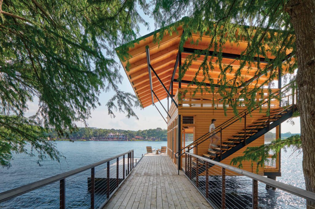 trees hang over a boathouse on a dock
