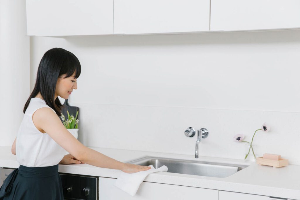 Kondo polishes a kitchen countertop.