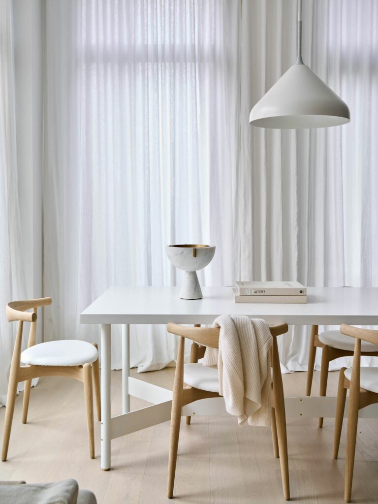 An Atlas Industries table, Carl Hansen chairs, and Pelle light fixture decorate the dining room.