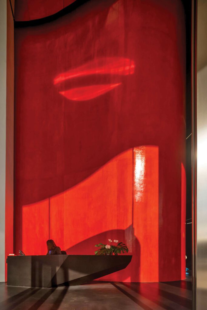 Walls in the lobby are lacquered red, the project’s—and the city’s—signature color.