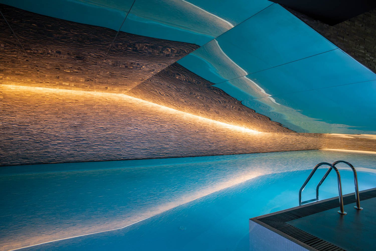 A strip of LEDs runs across the pool area’s stone-tile wall.