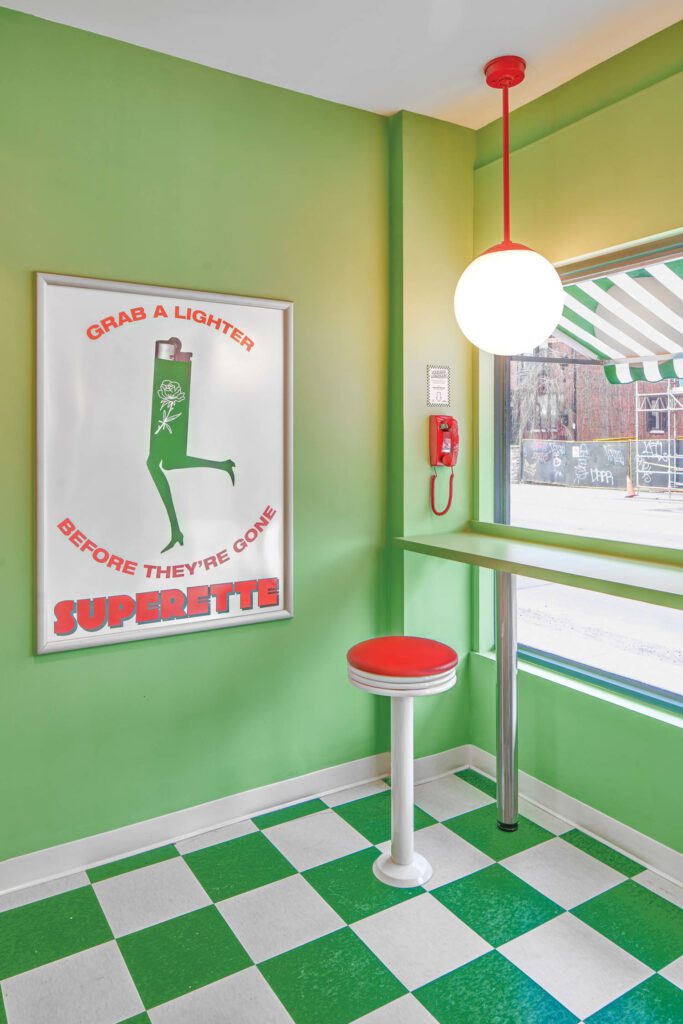 In the storefront of Superette Annex, a recreational cannabis dispensary, a Harman 1 pendant fixture by Ivy Bronx illuminates vinyl floor tile, a tubular-steel stool, and graphics by the brand’s in-house creative team.