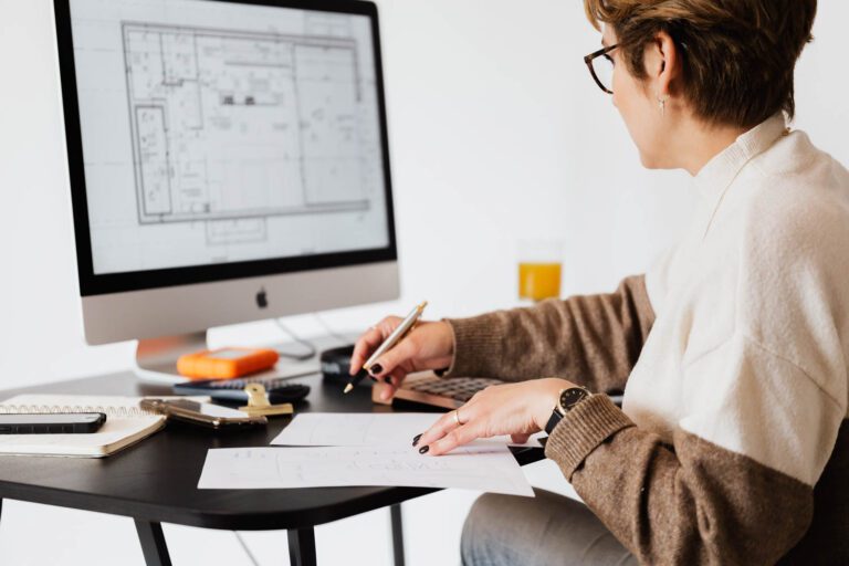 an architect works on floor plans on her computer