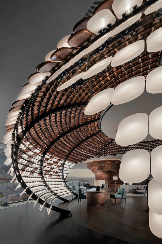 A cocoonlike structure in walnut and glowing acrylic disks houses reception.