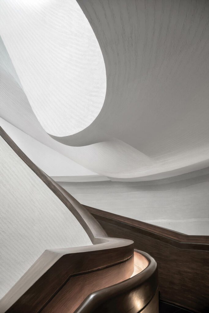 A sculp­tural staircase is lightly patterned with striations that mirror those found in rock formations.