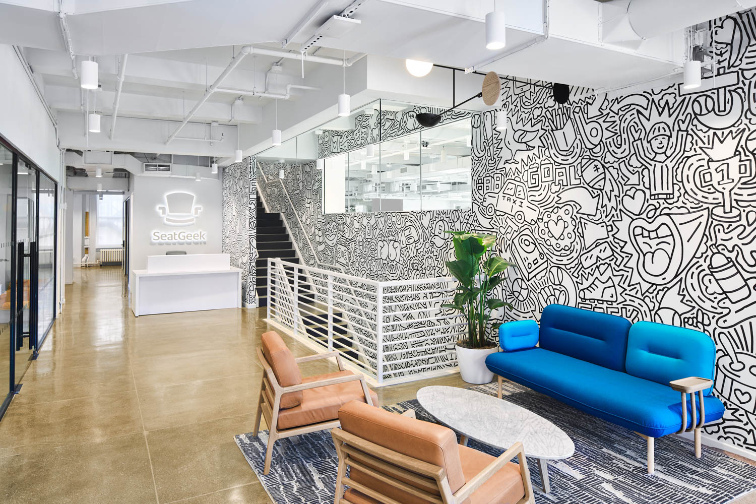 A lounge area with a punchy blue sofa in the office of SeatGeek