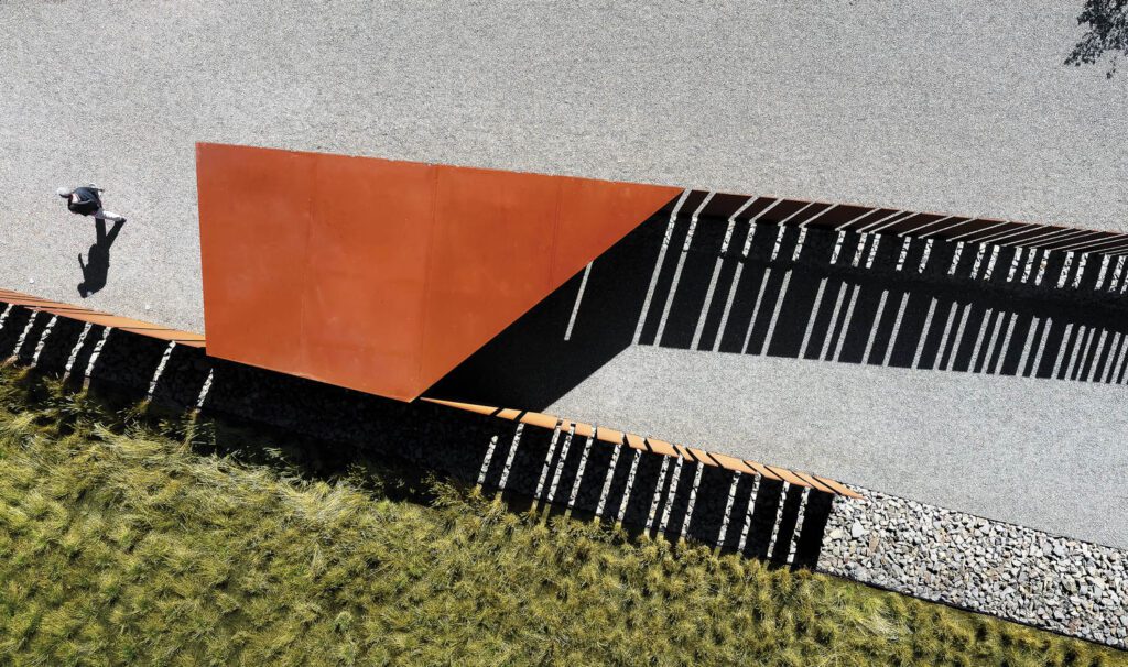a gate framed and topped by geometrically shaped Cor-Ten steel