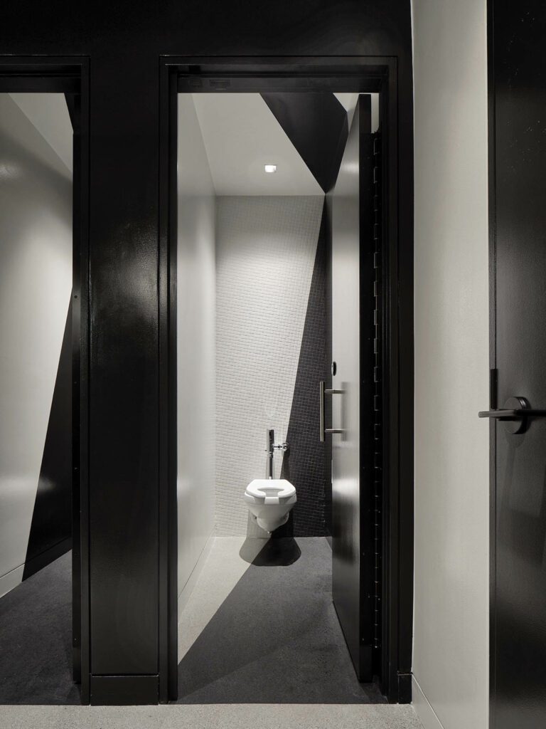 a black and white bathroom with angled tiles