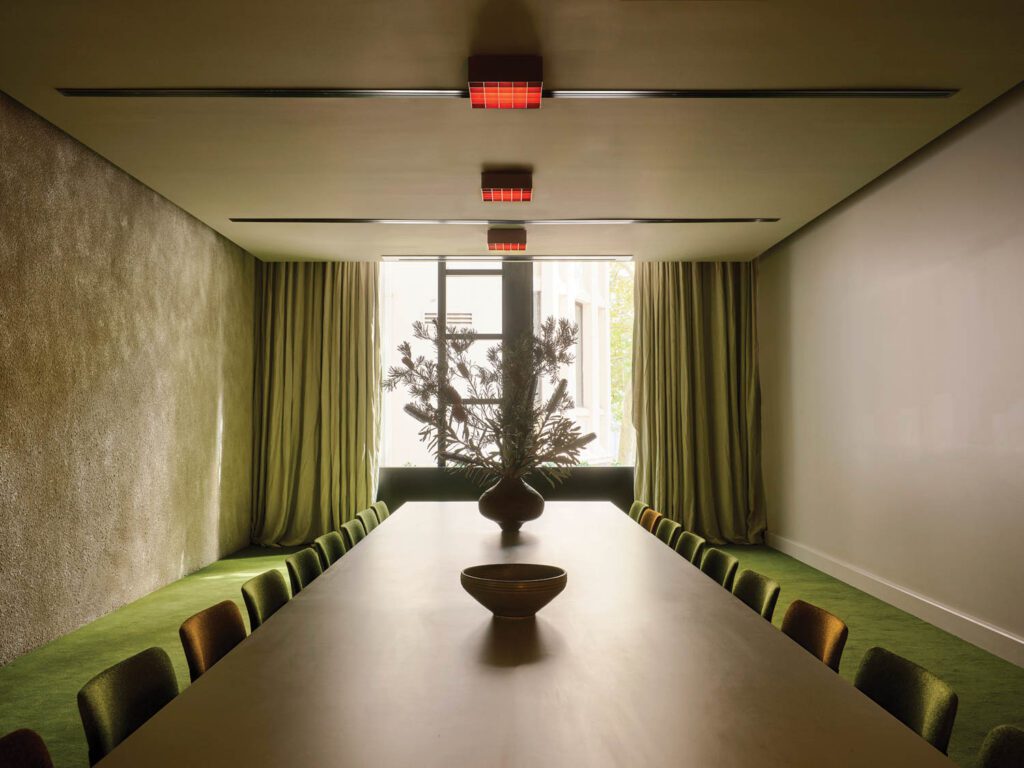 One wall in a meeting room is texturized with cement render, a finish used in many parts of the hotel.
