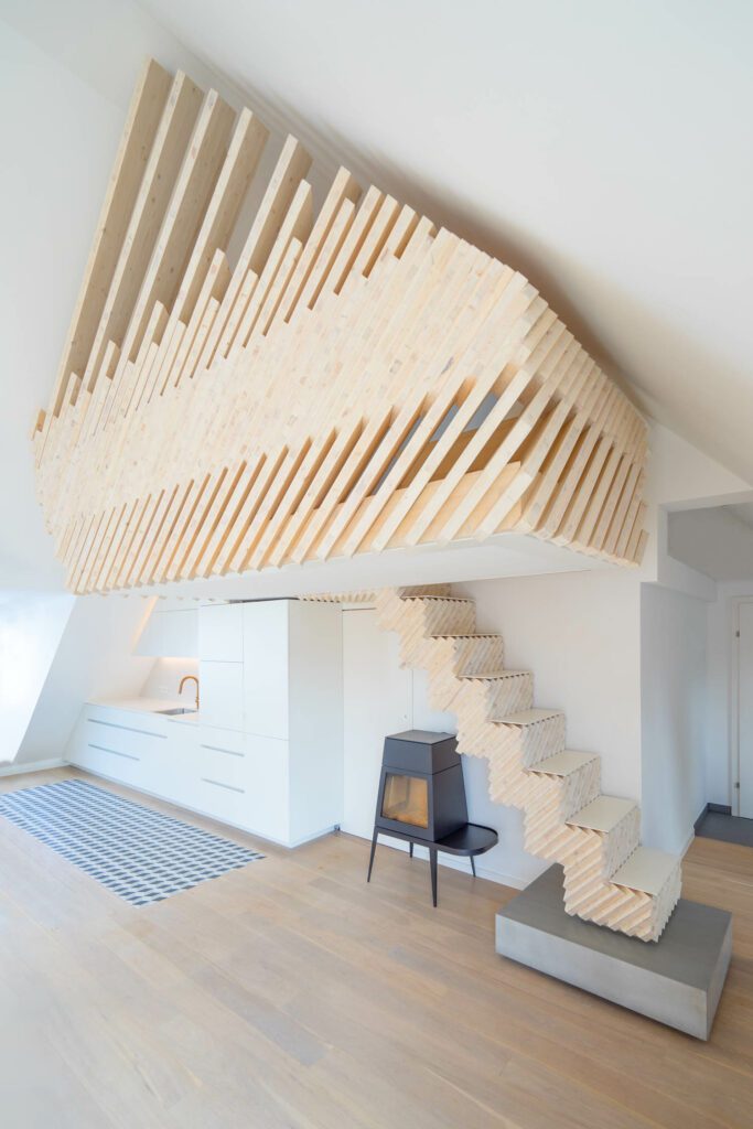A minimalist Shaker hearth by Skantherm sits beneath the stairs.
