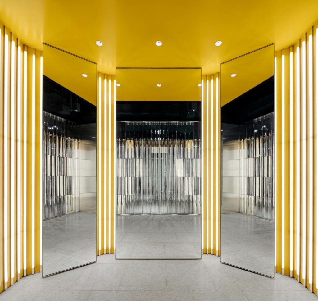The third floor changing room is illuminated by yellow hues and stripes of light. 