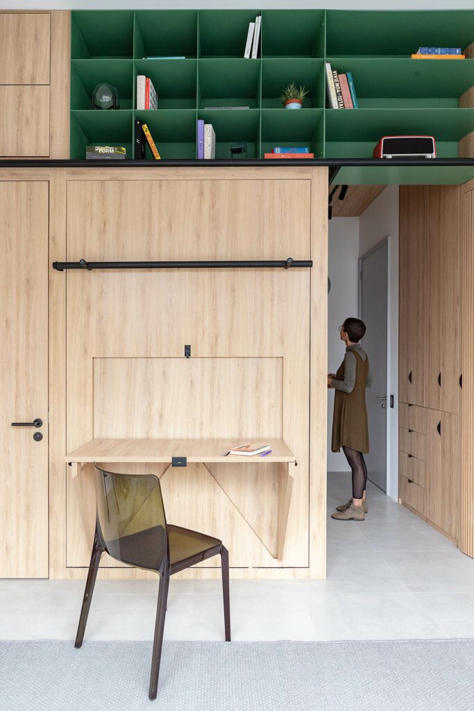 A hinged desk along a wall creates an ersatz office space.