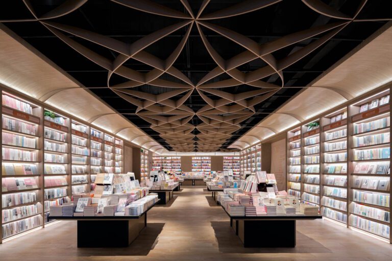 More timber-print aluminum inspired by paper art enlivens the ceiling of the retail area, which has custom display tables.