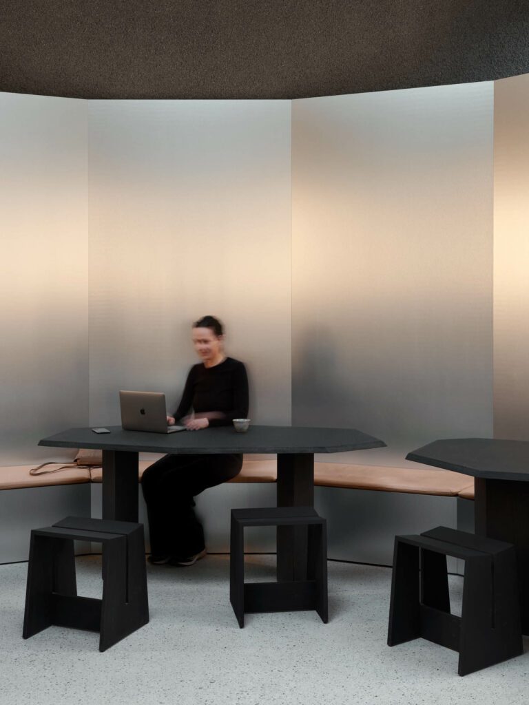 an open working area with brushed aluminum walls