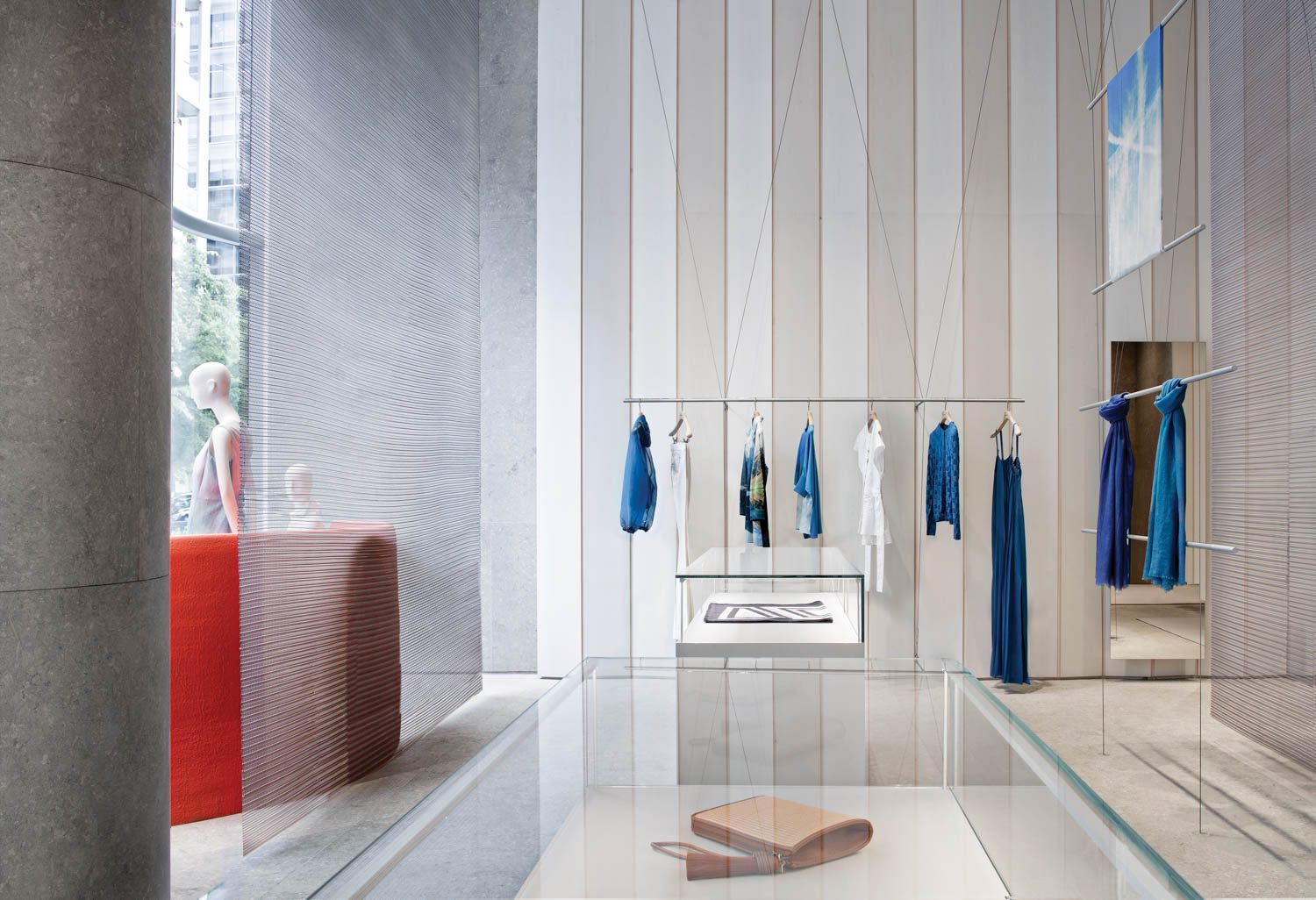 blue clothing hangs on a rack in the Akris store in Washington by David Chipperfield Architects