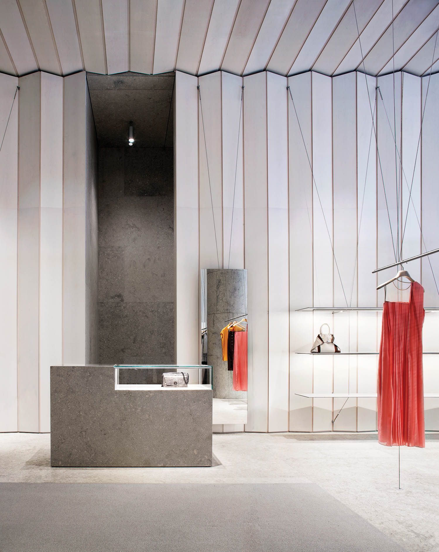a red dress hangs in the Akris store in Washington by David Chipperfield Architects