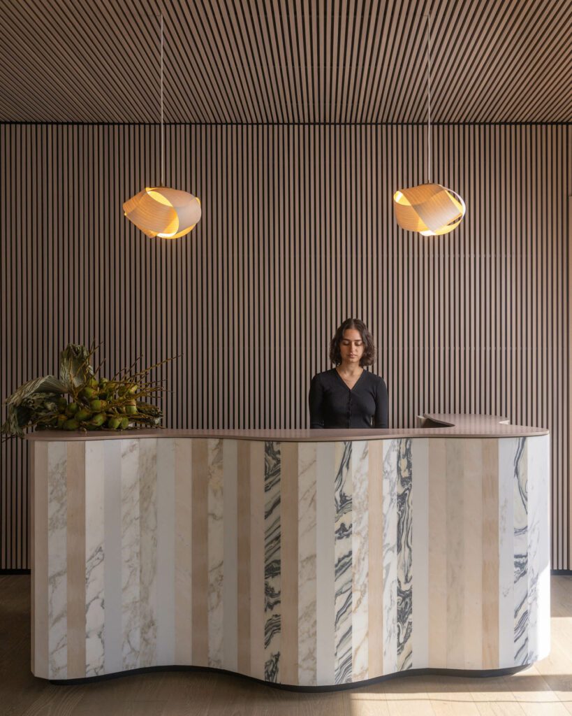 The reception desk features a gentle wave that reflects the maritime surroundings. 