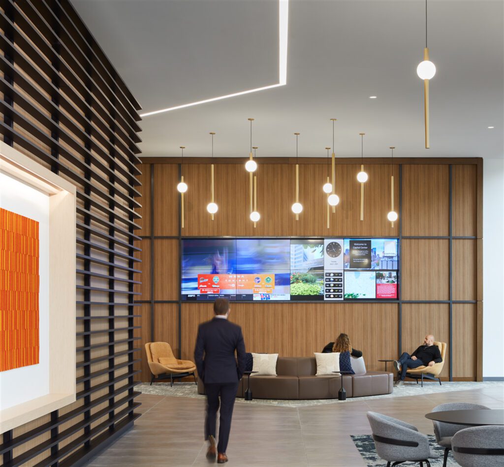 More than a circulation path, a media wall plus furnishings by Blu Dot and National Office Furniture provides a welcoming drop-in space illuminated by recessed Finelite linear lighting.
