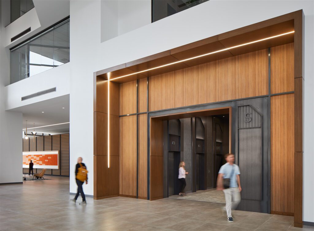 Stantec played off the existing architectural envelope, layering sophisticated, integrated lighting by Zumtobel and Banker Wire mesh at the elevator lobby.