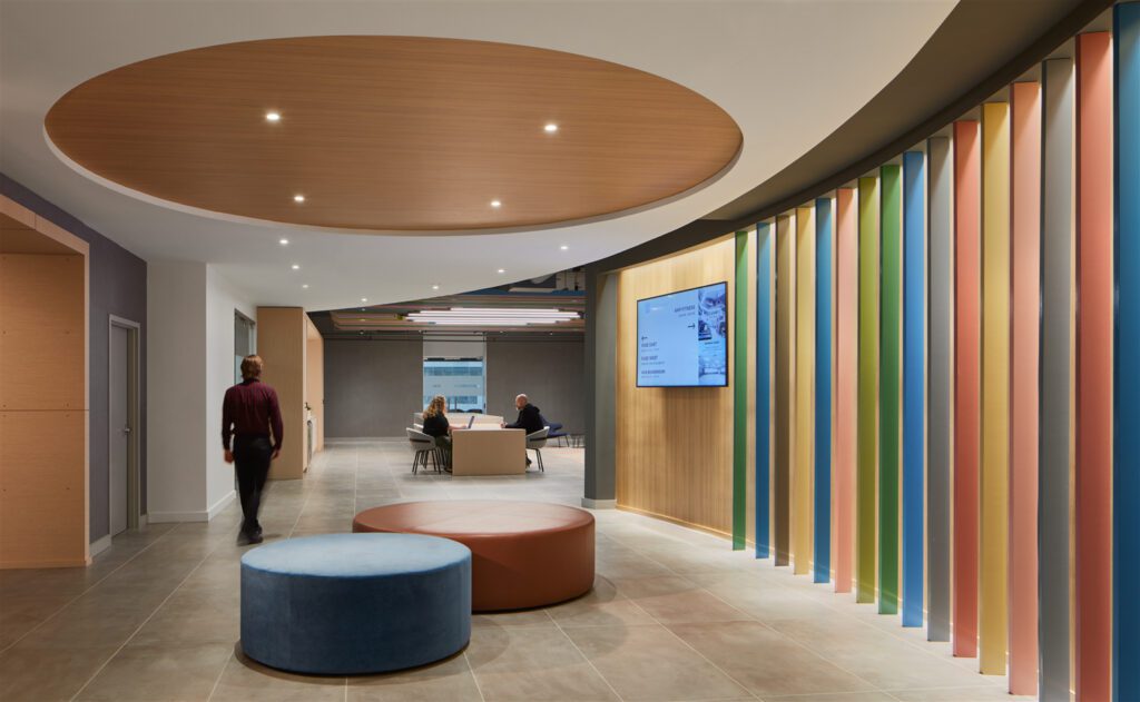 Soft, curved custom millwork in an invigorating array of colors carves the conference center’s pre-function space from a tight and complex floor plan.